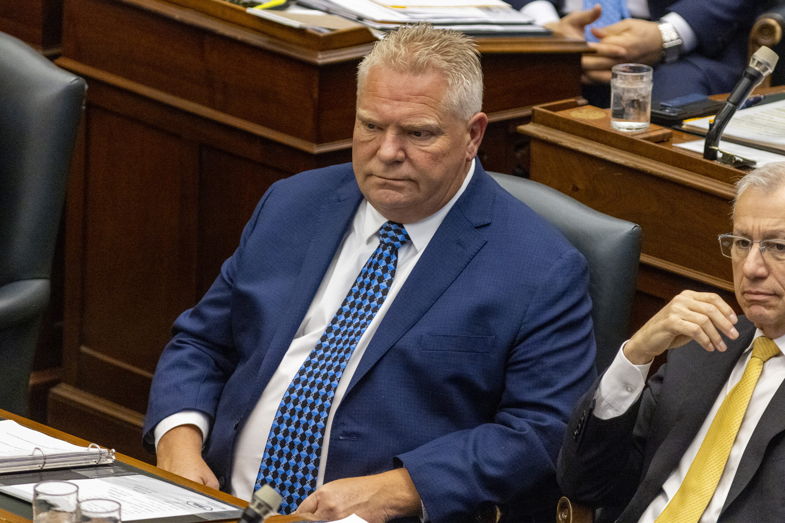 Greenbelt scandal: Premier Doug Ford sits at a desk inside the Ontario legislature