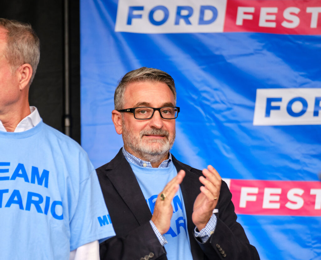 Greenbelt scandal: Paul Calandra claps in front of a banner that says "Ford Fest"