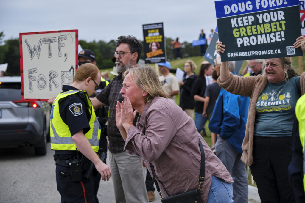Greenbelt scandal: protestors with signs saying "Doug Ford: keep your Greenbelt promise" and other slogs