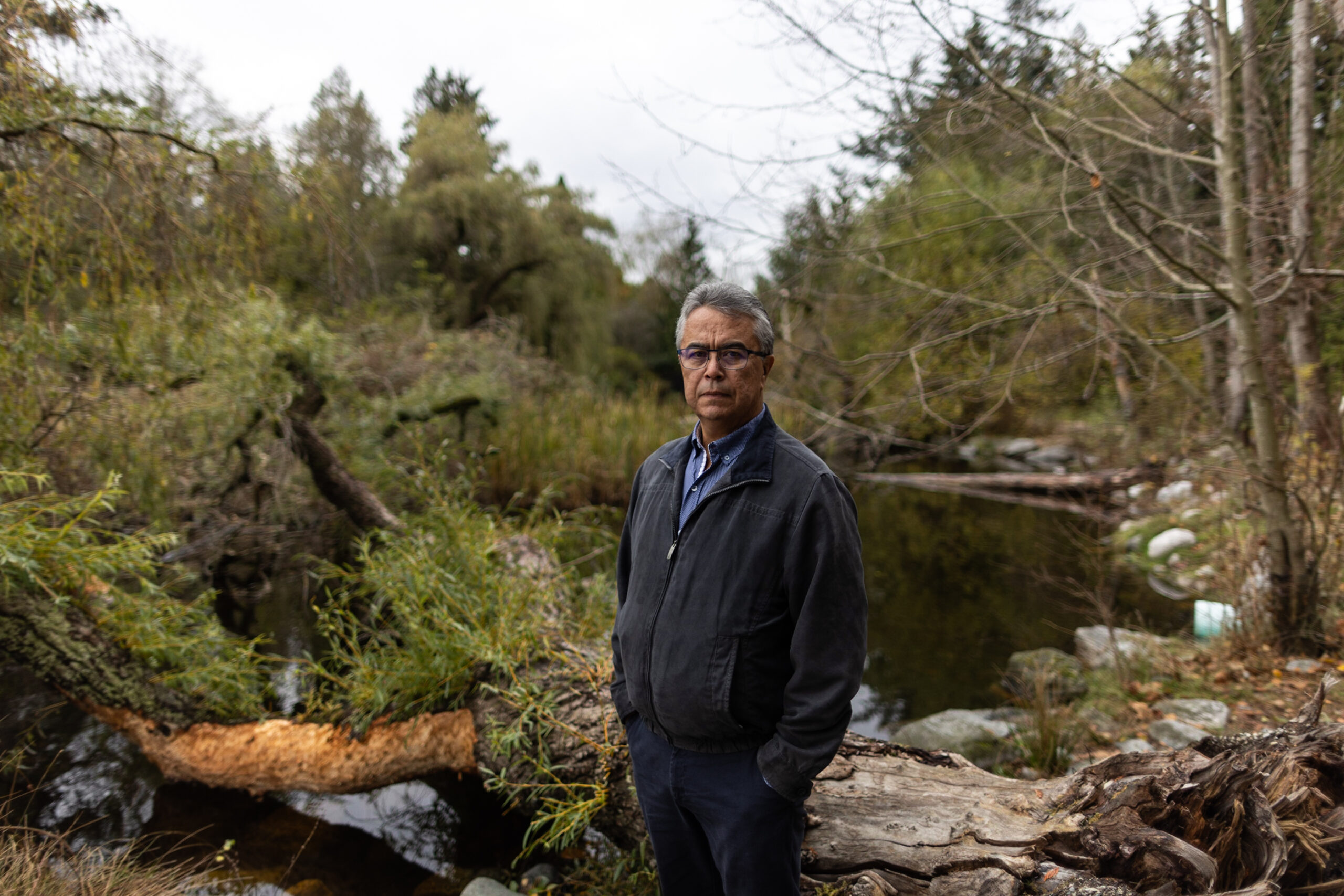 Tyrone McNeil poses next to a pond surrounded by greenery