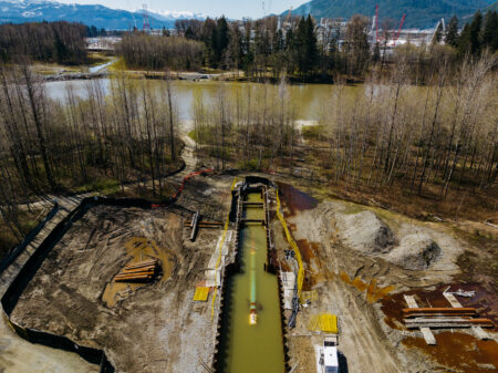 Overhead view of Coastal GasLink pipeline during construction, with muddy Kitimat River and partially flooded worksites
