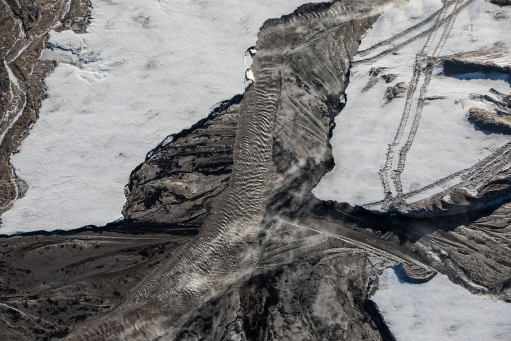 Snow, ice and liquid converge in a tailings pond at a Suncor open pit oilsands mine