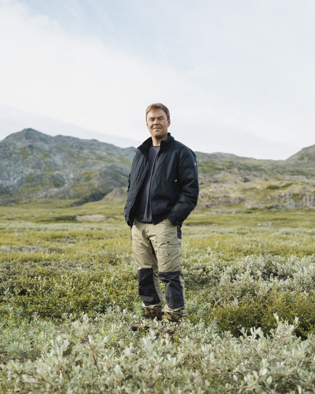 Andrew Anderson, an Inuk Parks Canada employee, is pictured at Basecamp with the landscape behind him.