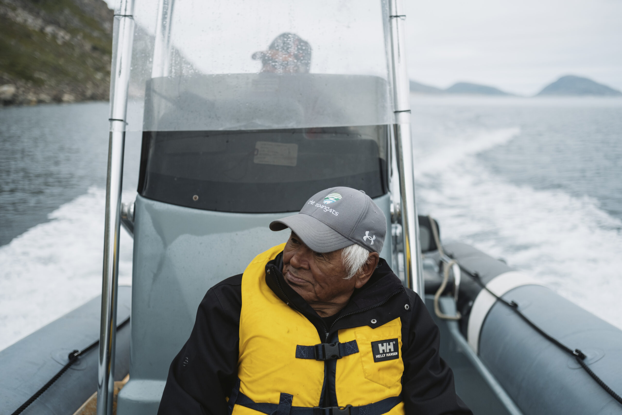Torngat Mountains National Park: Eli Merkuratsuk sits at the front of a Zodiac boat on the waters of Saglek Fiord in the Torngat Mountains
