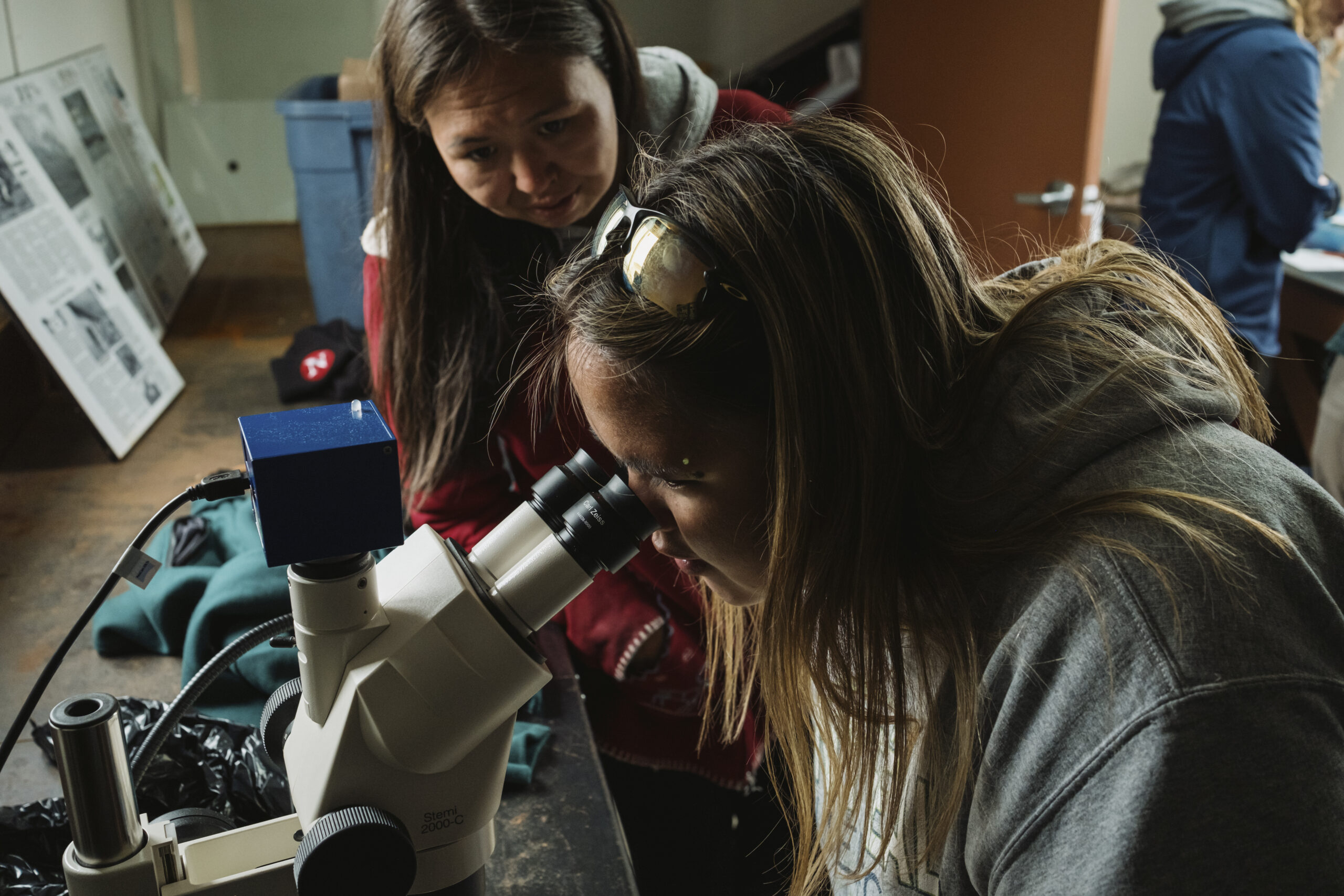 Destiny Solomon and Simone Daniels look at a char sample under the microscope at Torngat Mountains National Park basecamp.