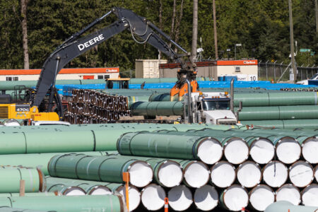 Equipment moves segments of the Trans Mountain pipeline expansion in a work yard as the pipeline is under construction near the Trans-Canada Highway
