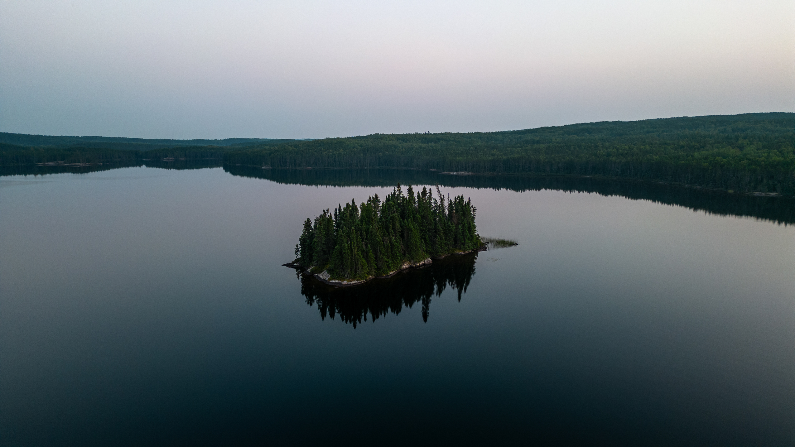 Aerial view of a lake with a small island at the Institute for International Sustainable Development Experimental Lakes Area (IISD-ELA), known as the world's largest outdoor experimental freshwater research facility of its kind.