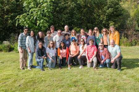 The Narwhal's staff pose, all smiles, for a team photo in a grassy area with trees behind them.
