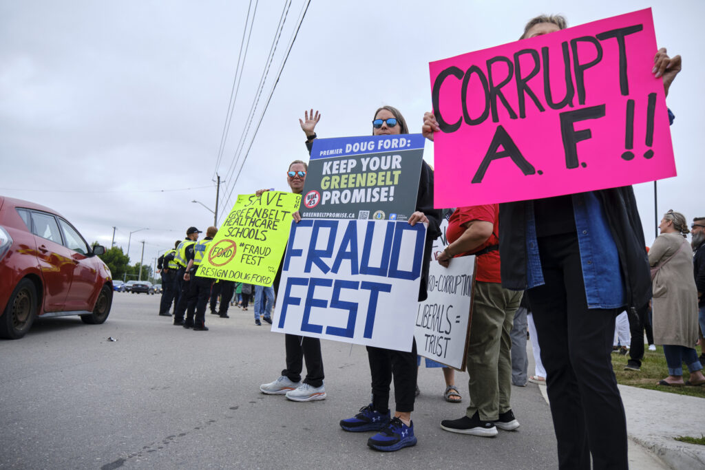 Ontario Greenbelt: protestors with signs reading "corrupt AF," "keep your Greenbelt promise" and "fraud fest"
