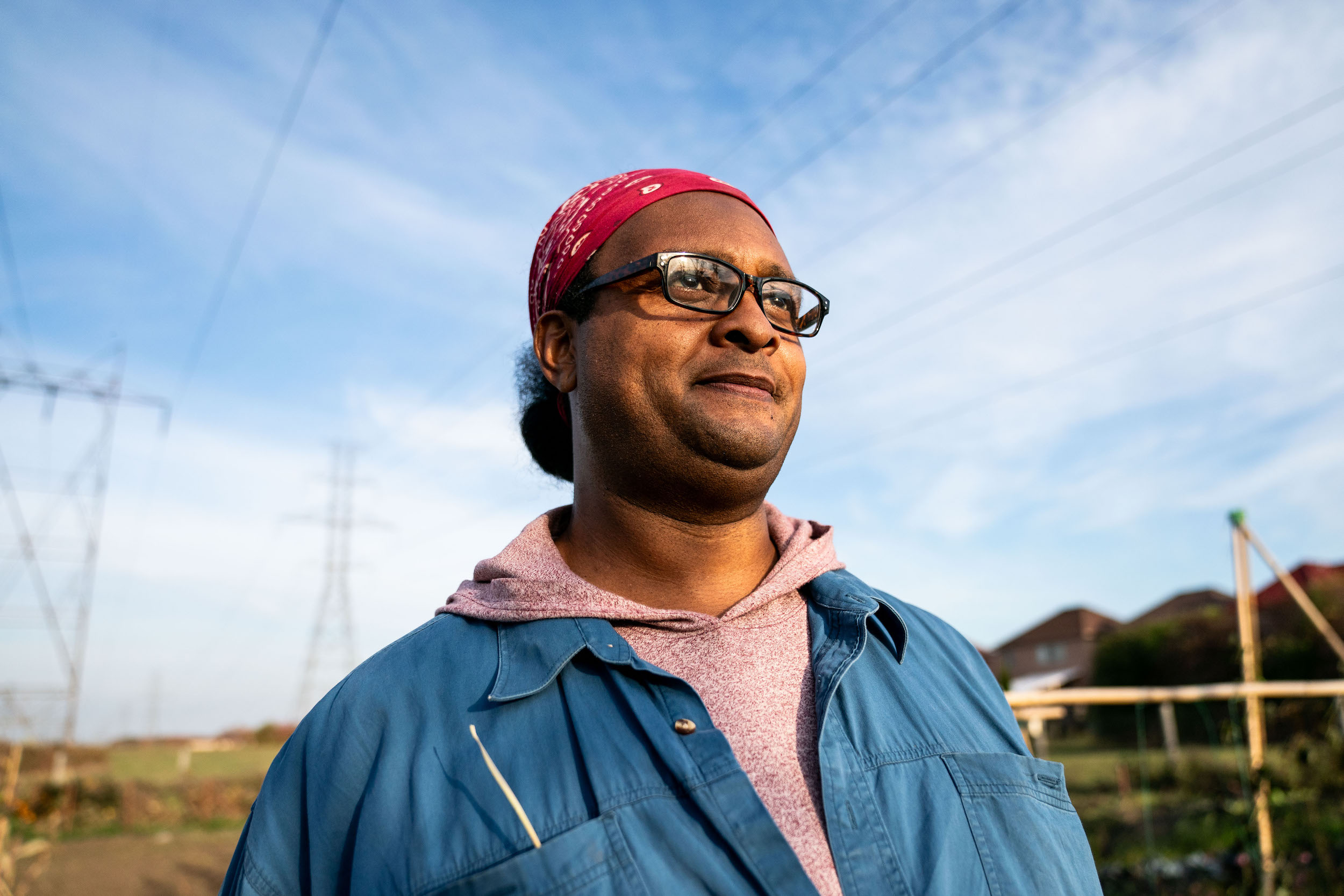 Afro-Indigenous farmer Isaac Crosby looks over at the farming plot at Crosby Gitigaan in Malvern Urban Farm in Scarborough, Toronto