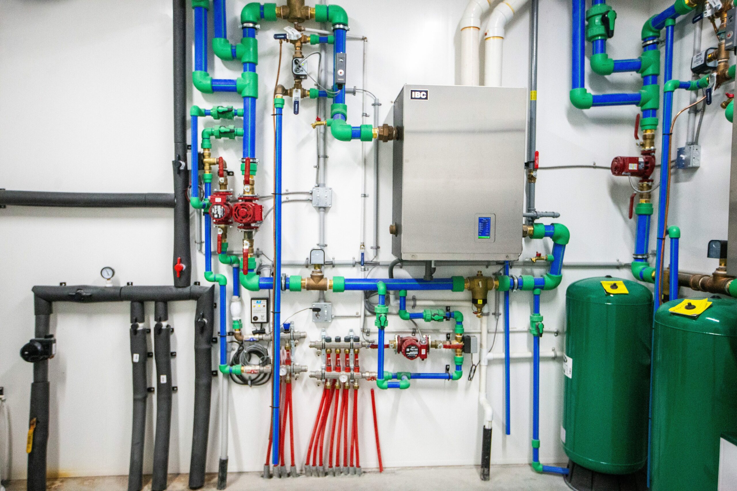 Blue, green and red piping feed into a silver box on the wall which controls the heating on a Manitoba egg farm