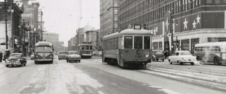 Streetcar no. 728 runs down Winnipeg's Portage Avenue in 1954. Cars and buses share the road on either side of the streetcar tracks