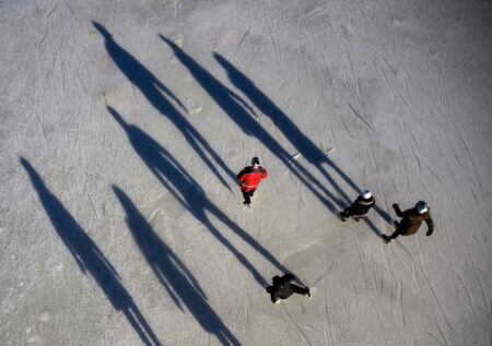 People cast long shadows as they skate on the Rideau Canal Skateway on its opening day in Ottawa, on Sunday, Jan. 21, 2024. Skaters flocked to the ice, one year after warm and wet weather prevented the 7.8 kilometre skateway from opening for its 2023 season.