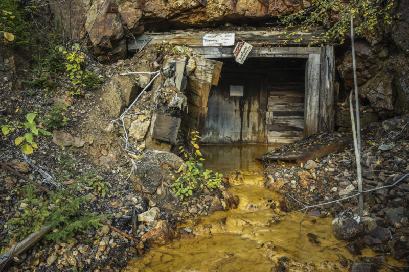 Orange liquid or acid mine drainage leaks from an opening to the closed Tulsequah Chief Mine, in British Columbia.