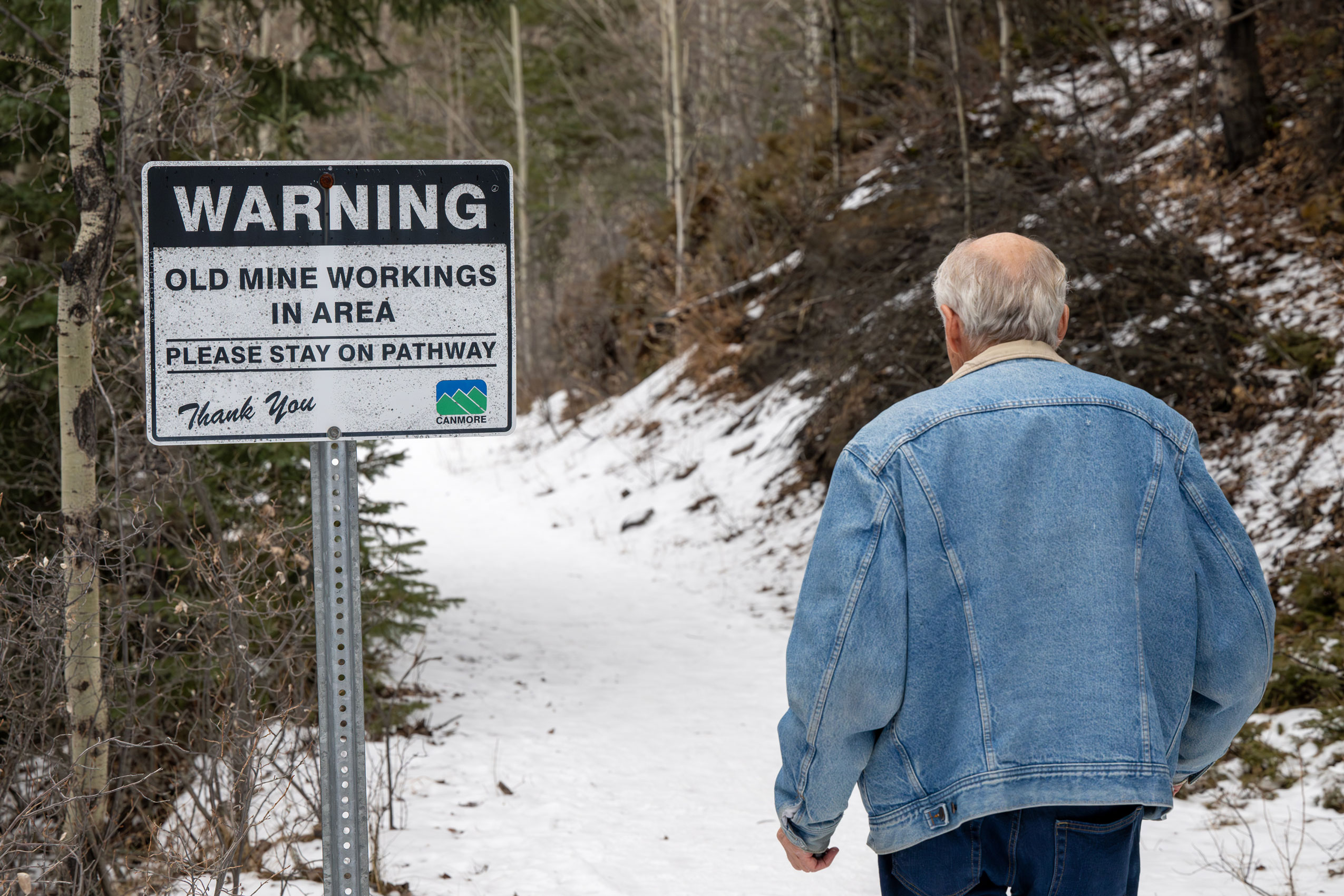 Raymond Haimila, a former miner, walks a path that warns of old mine works in Canmore, Alberta