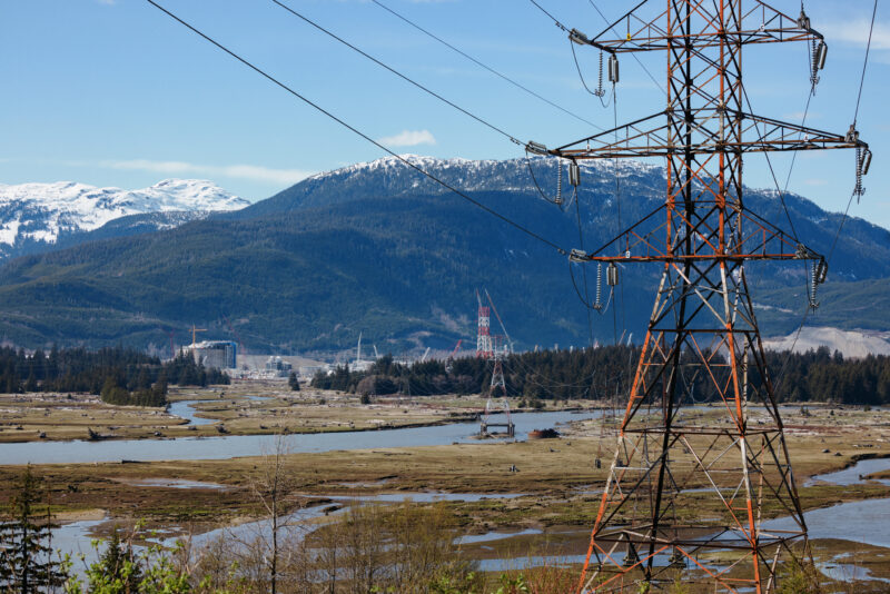 a transmission line tower in Kitimat with the LNG Canada project in the background