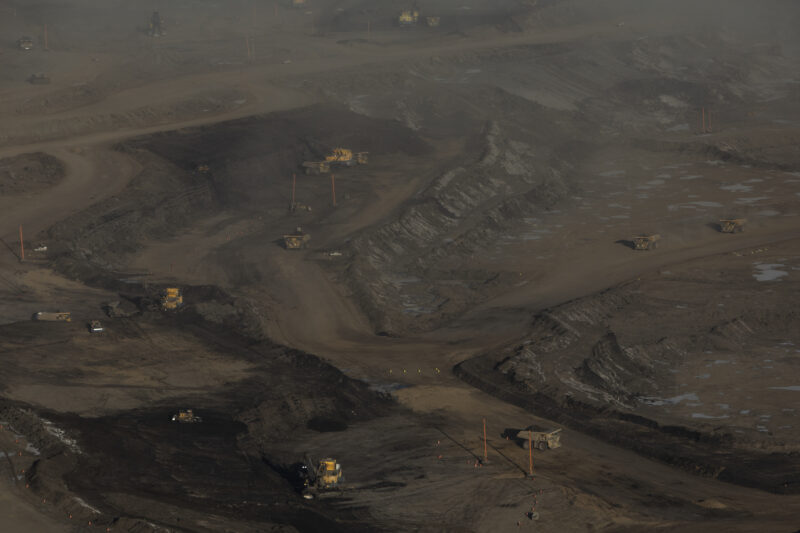 Aerial photo of heavy equipment operating on the brown expanse of an oilsands mine