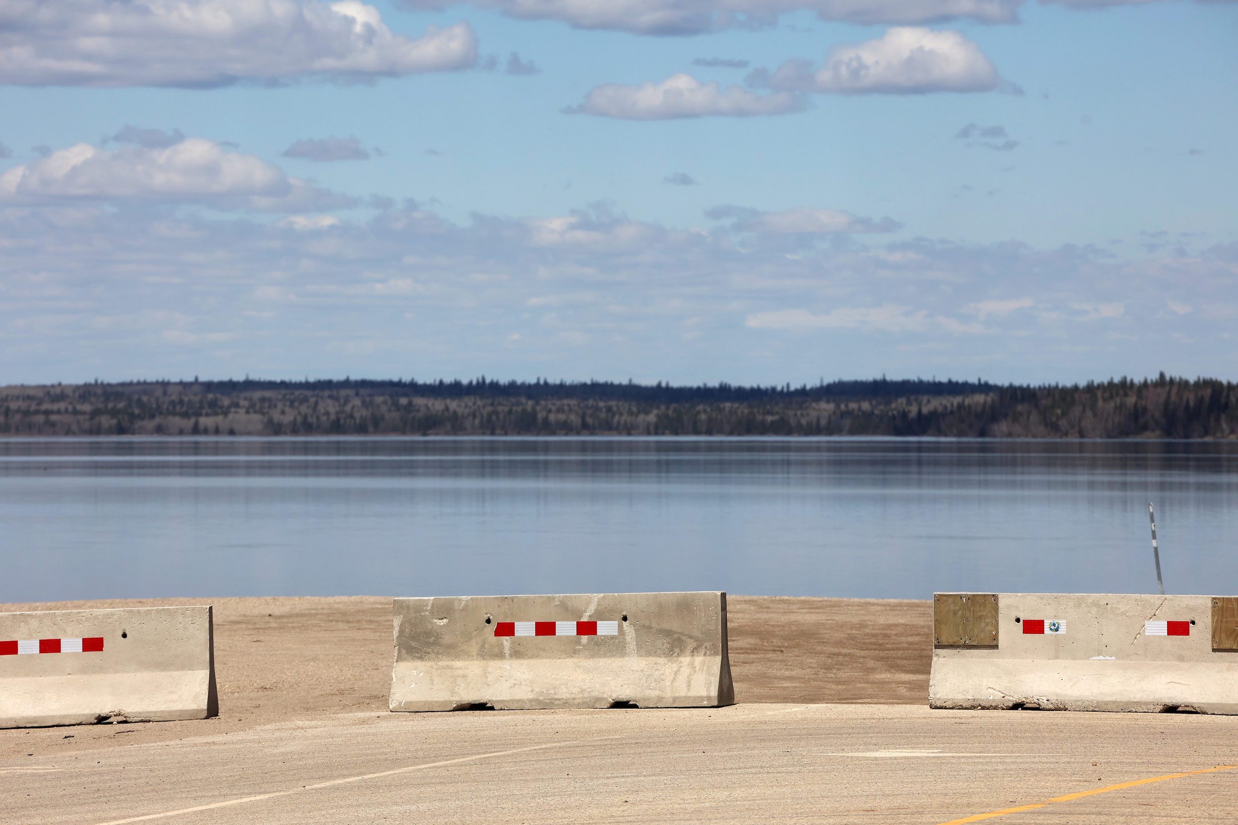 Concrete barriers block vehicle and boat access to the Wasagaming boat launch at Clear Lake in Riding Mountain National Park
