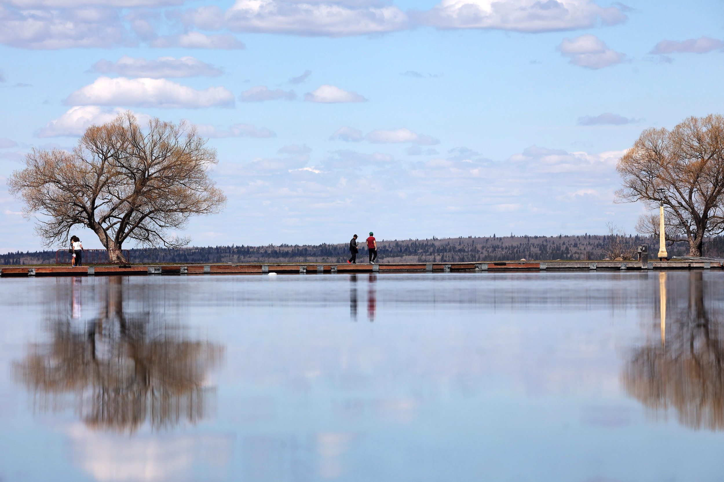 Clear Lake: Visitors to Riding Mountain National Park walk along the Clear Lake pier in Wasagaming on a calm and sunny Thursday.