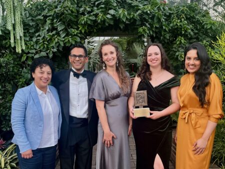 Francesca Fionda, Mike DeSouza, Elaine Anselmi, Emma McIntosh and Fatima pose for a photo with the Michener Award Trophy, dressed in fancy clothes
