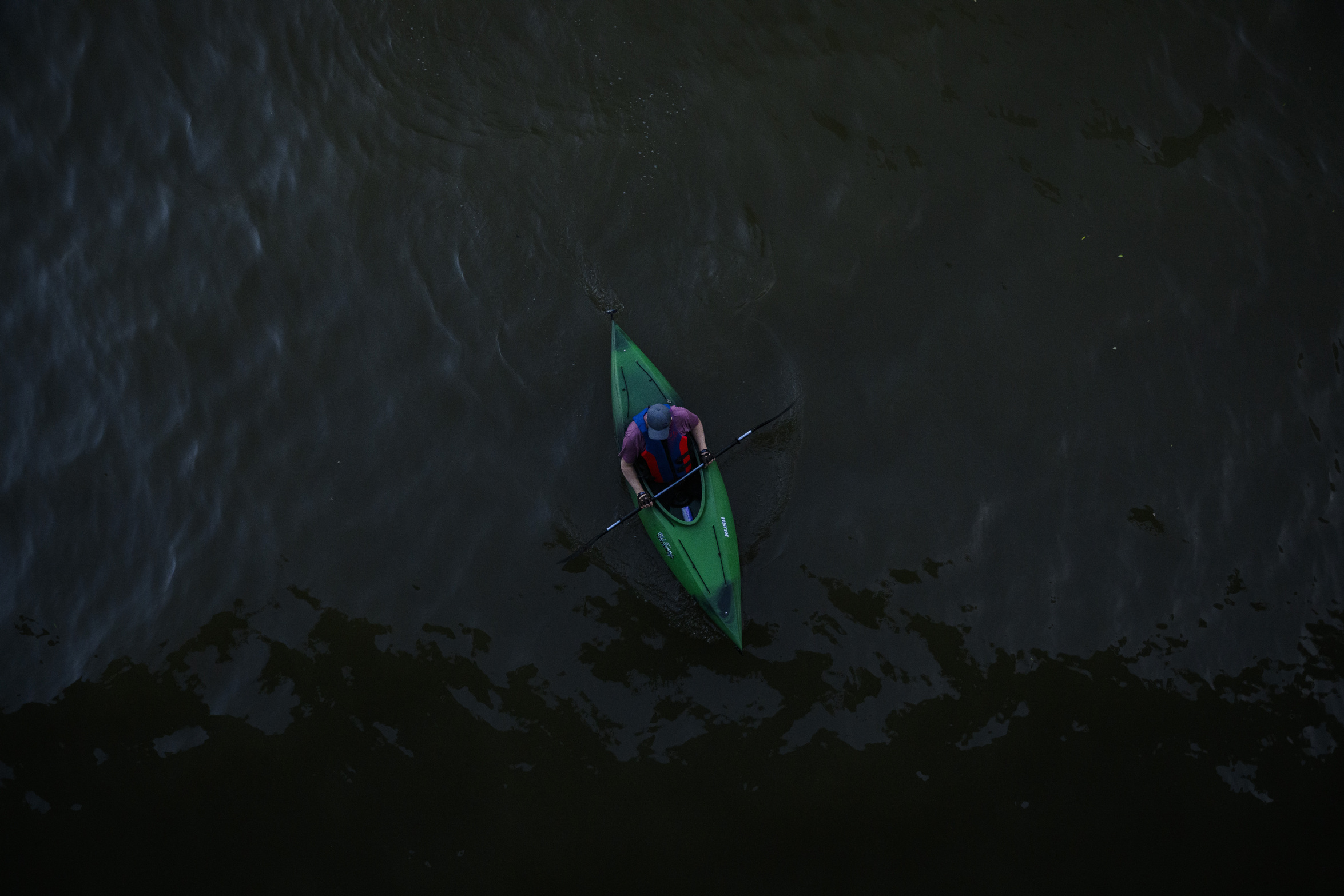 Green* Economy: a person paddling a kayak in the moody waters of Lake Ontario is seen from above