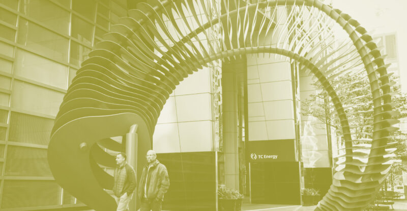 Two people walk down a sidewalk in front of a large commercial building with a "TC Energy" sign at the entrance. They pass through a large sculpture: a twisted spiral segment of stacked sheet metal forms tied through with three large rods. Photo is illustrated with a yellowish tint.