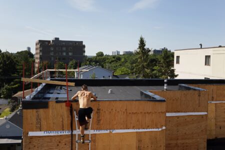 Taylor Fry of Bellissimo Roofing & Exteriors climbs to an upper roof while on a job in Ottawa, Ontario, Canada July 2, 2024. Photograph by Blair Gable for The Narwhal
