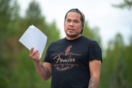 Simogyet (Chief) Gamlakyeltxw Wil Marsden holds a copy of a pipeline benefits agreement before burning it at a blockade on Gitanyow lands