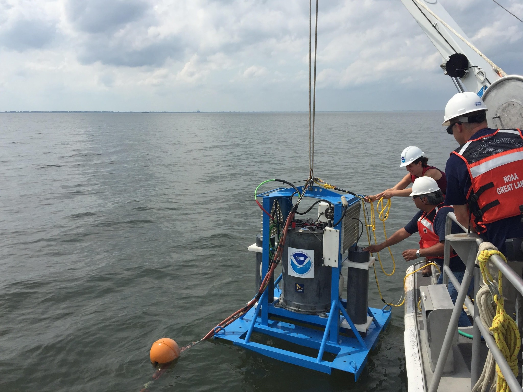 A team from the U.S. National Oceanic and Atmospheric Administration on a boat, deploying a second generation environmental sample processor. This device collects and analyzes water samples in near-real time, enhancing scientists' understanding of toxicity in the Great Lakes.