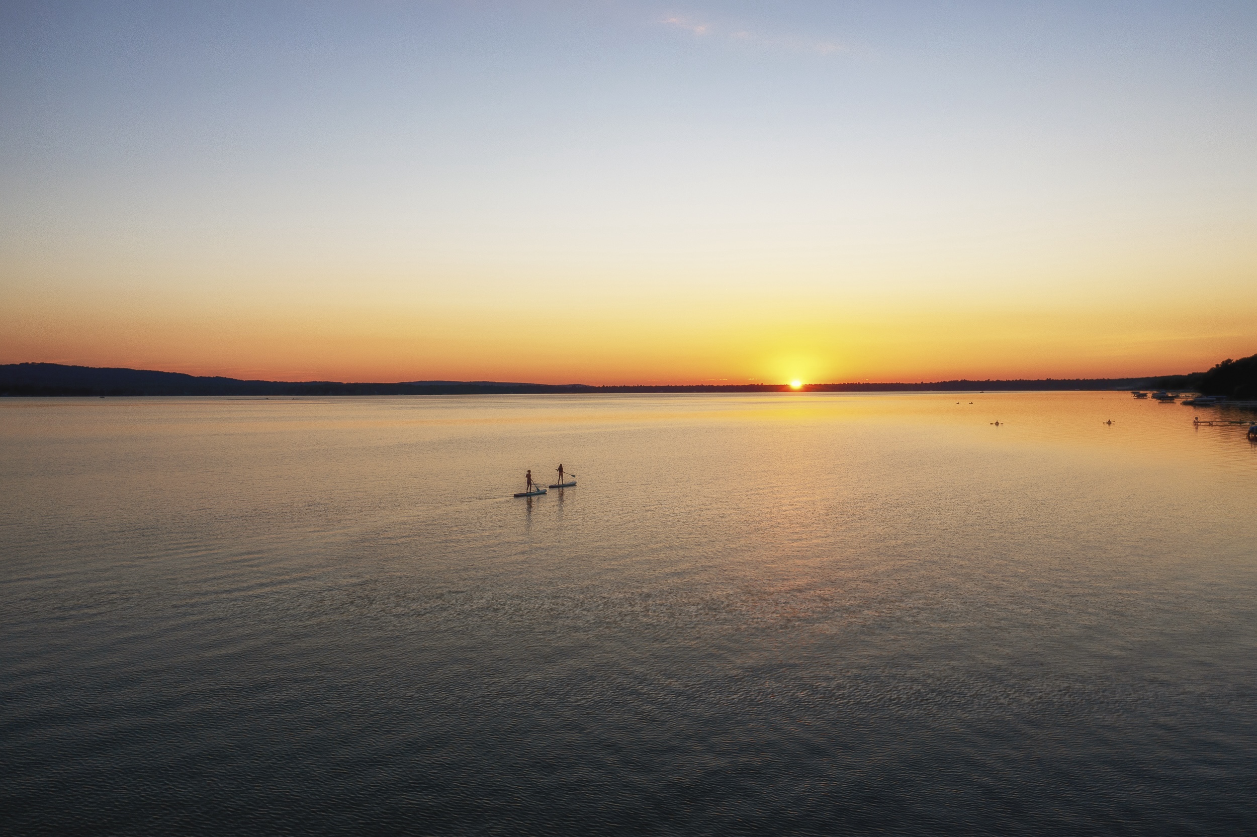 Paddle boarders cross Platte Lake, Mich., where a decades-long campaign reduced algal blooms caused by runoff from a fish hatchery.