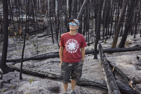 Michelle North stands in a forest burned by a wildfire near her Gun Lake cabin