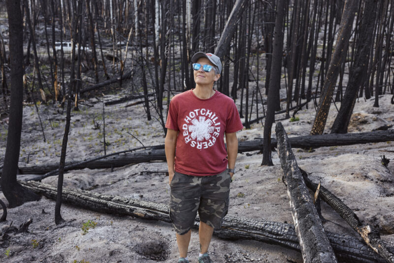 Michelle North stands in a forest burned by a wildfire near her Gun Lake cabin