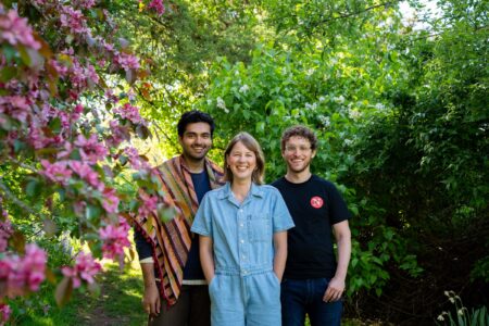 Narwhal audience team members, left to right: Karan Saxena, Kathryn Juricic and Arik Ligeti are seen surrounded by flowers and trees.
