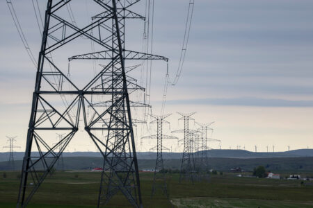 Transmission lines and towers stretch off in the distance, carrying electricity in Alberta.