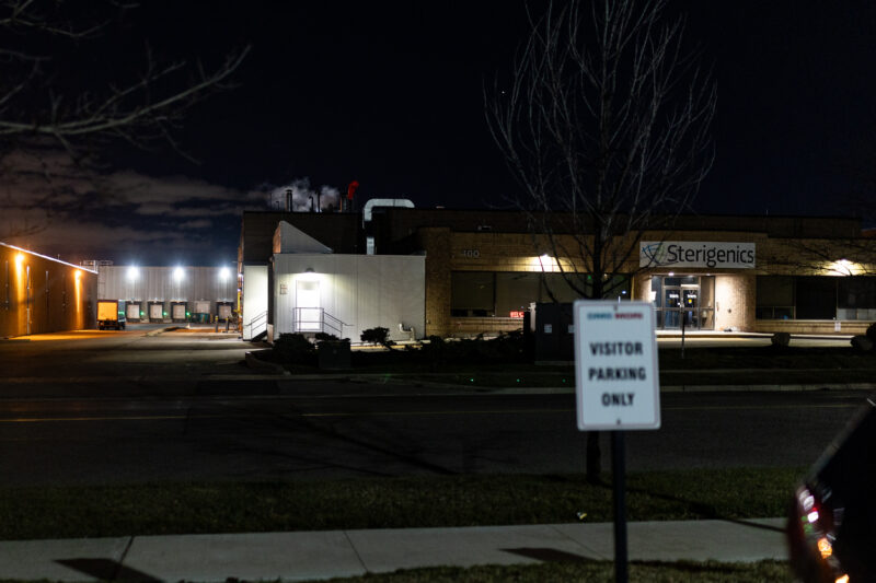 A factory lit up at night, with a sign on the front reading Sterigenics