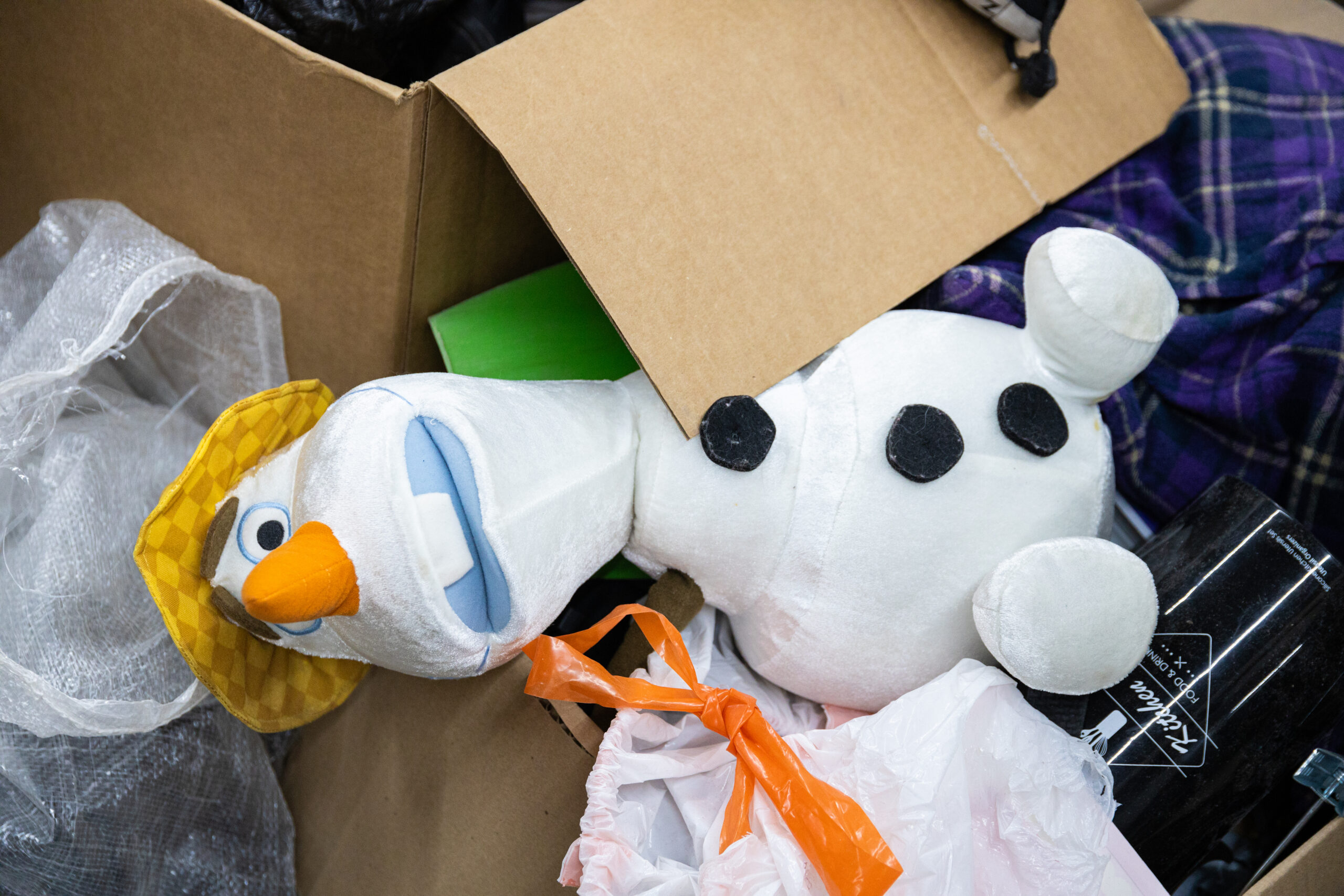 A stuffed snowman lays atop a pile of donated items to be sorted at a Winnipeg thrift store

