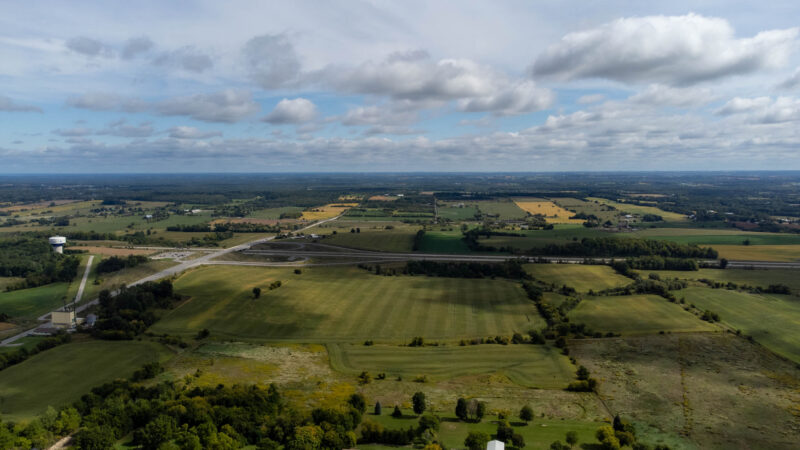 An aerial view of an empty highway running through farmland