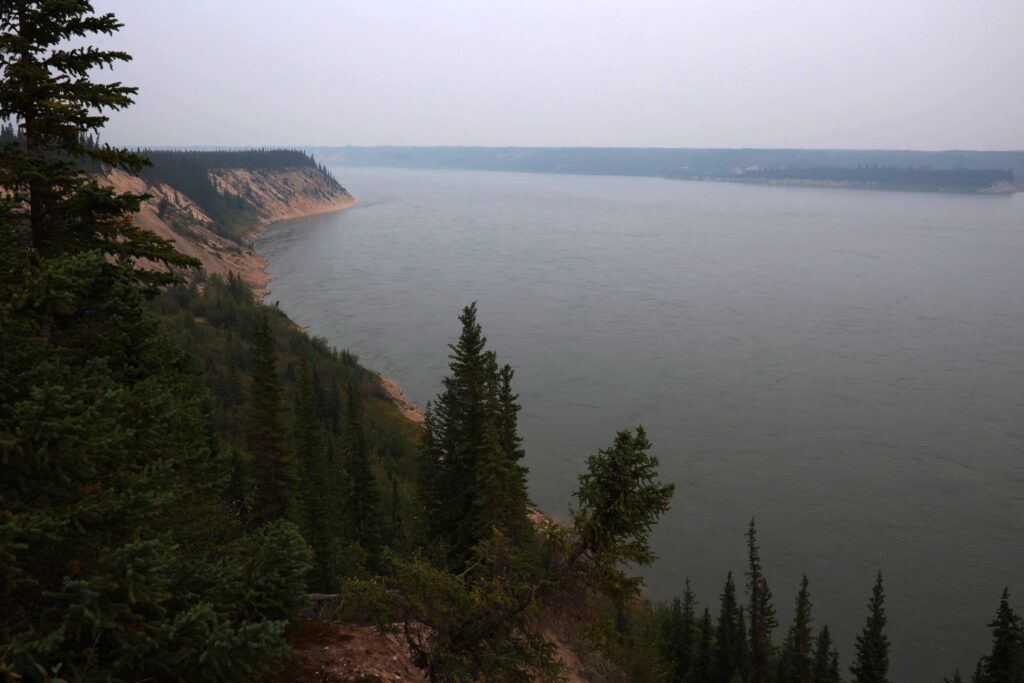 Northern Manitoba's Nelson River curves through the landscape flanked by tall, sandy cliffs under the haze of wildfire smoke during the launch of the Kitaskeenan protected area