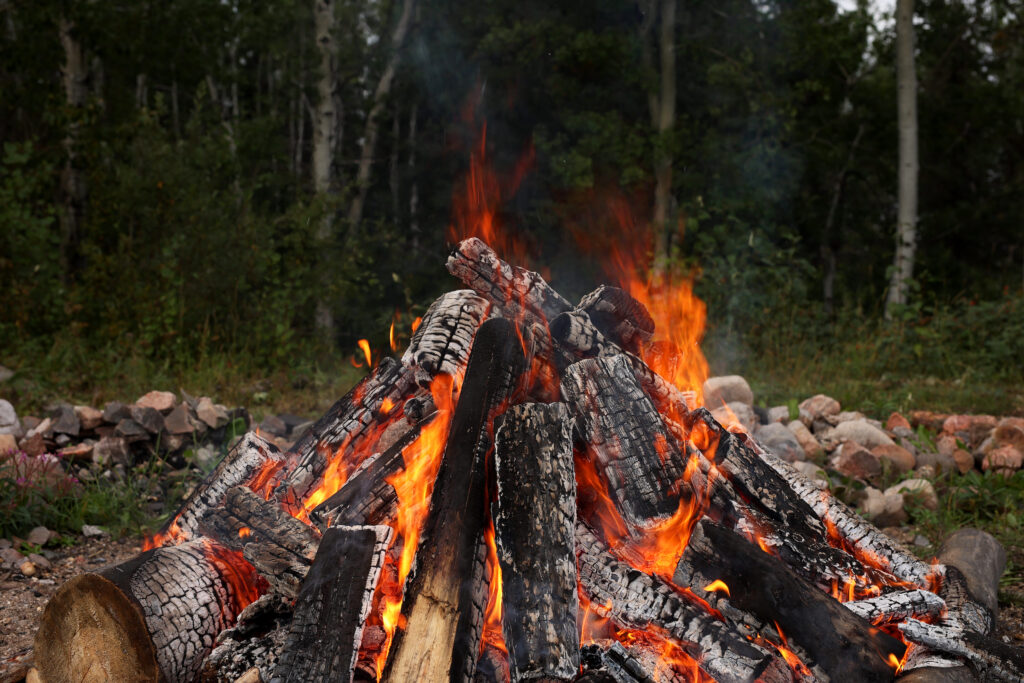 Stones are heated in a fire to be used in the sweat lodge at the Kitaskeenan Kaweekanawaynichikatek Fox Lake Cree Nation Culture Camp