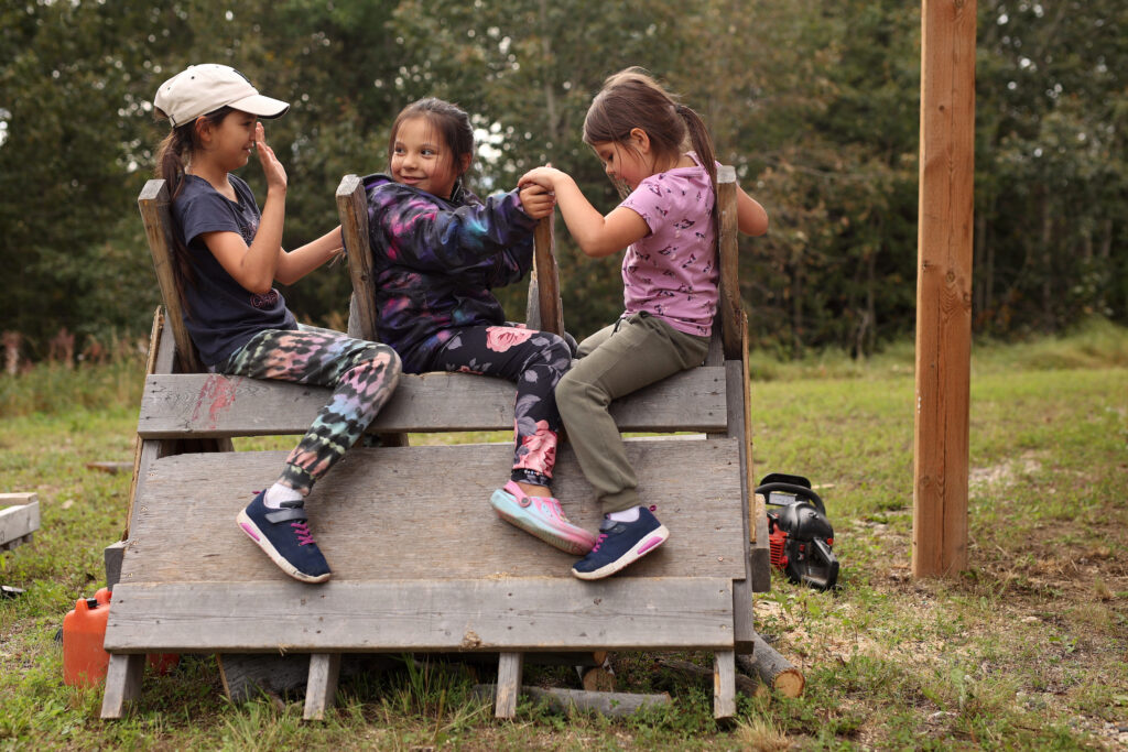 Children play on a wood structure