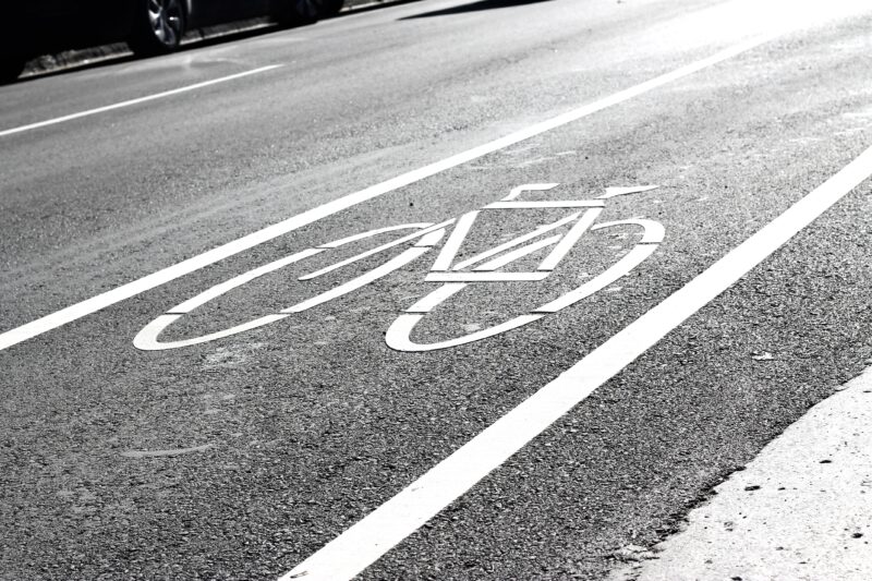 A white bicycle and lines painted on a paved road