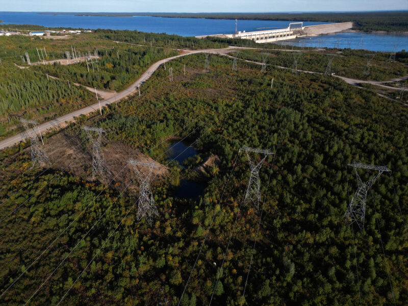 Manitoba Hydro transmission lines seen from above with Nelson River and dam in background