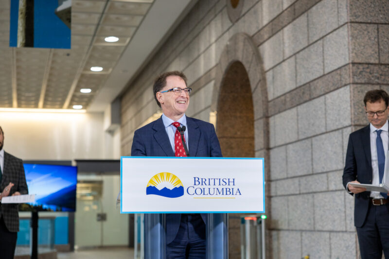 Energy and Climate Solutions Minister Adrian Dix stands at a podium to announce that wind projects in BC will no longer be subject to environmental assessments