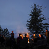 A group of people sits around a campfire in Bamfield, B.C.