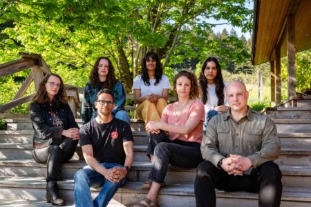 Seven Narwhal staff members sit on outdoors steps