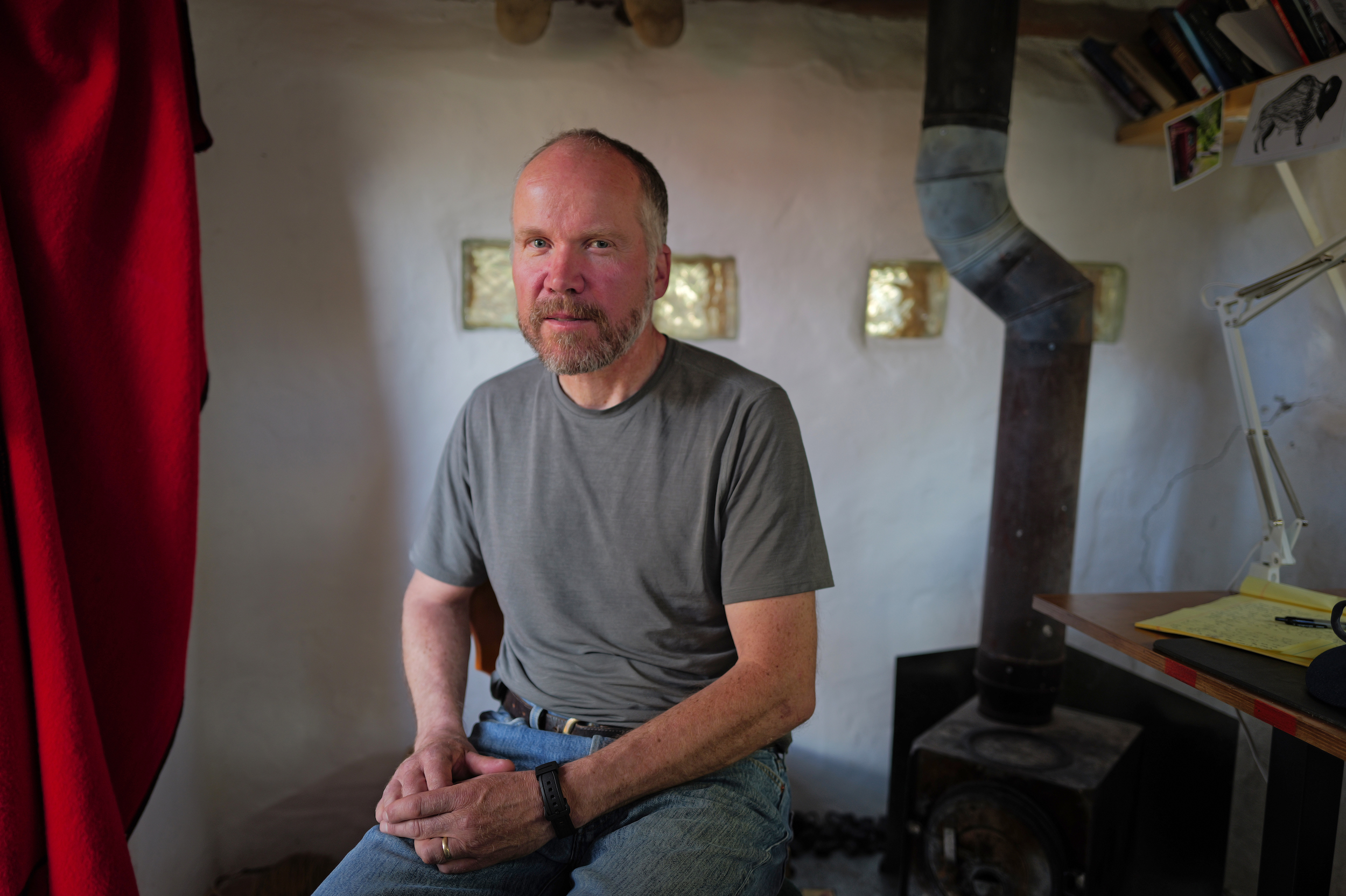 Karsten Heuer sits in a workshop next to a wood stove