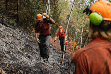 BC Wildfire Service firefighters on a steep, sooty slope