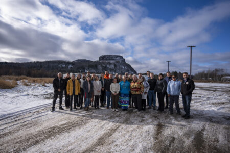 A group of people stand ouside in the snown