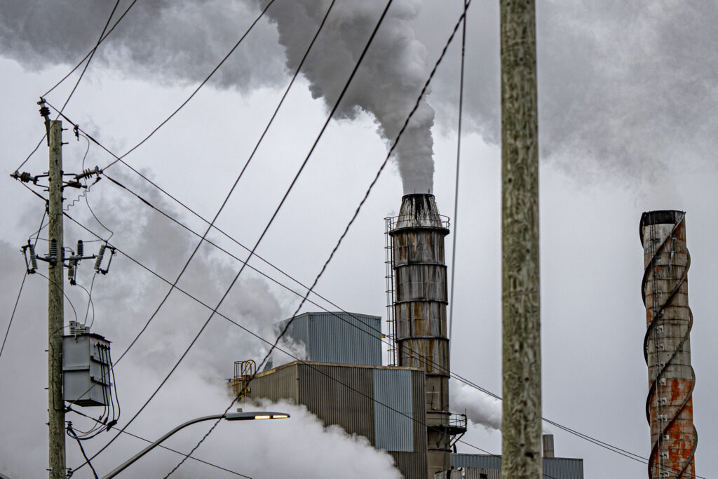 Smokes pours out of stacks on the roof of a pulp mill in Terrace Bay, Ont.