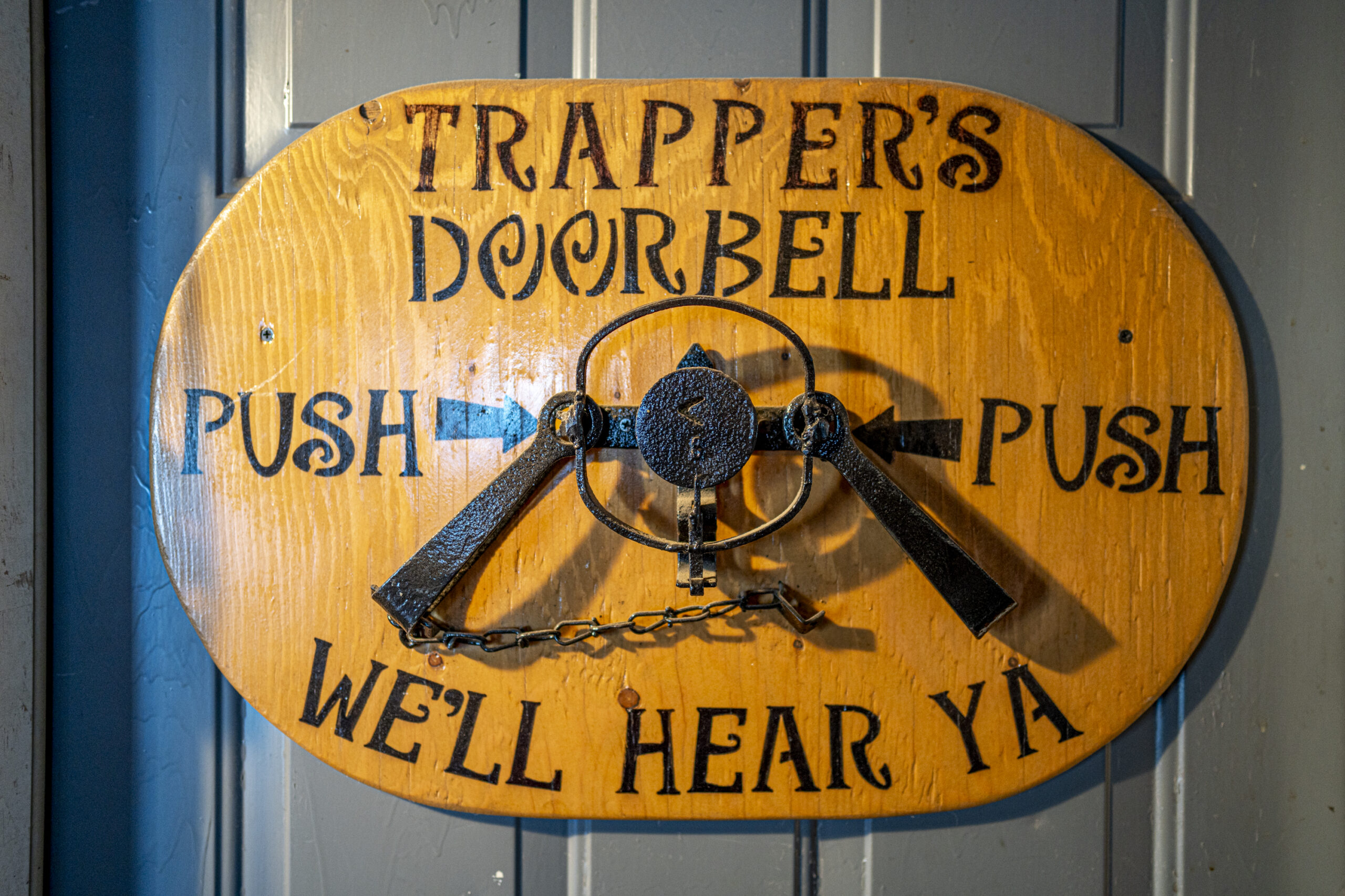 A sign on a door reads 'Rapper's Doorbell' displaying an ankle trap, and reading below it 'we'll hear ya'